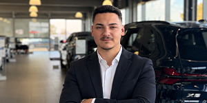 Portraitfotos eines jungen Mannes im Anzug, in einem Autohaus