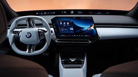 Moderner Innenraum des BMW i3 mit Lenkrad, zentralem Touchdisplay und breitem digitalen Anzeigebereich.